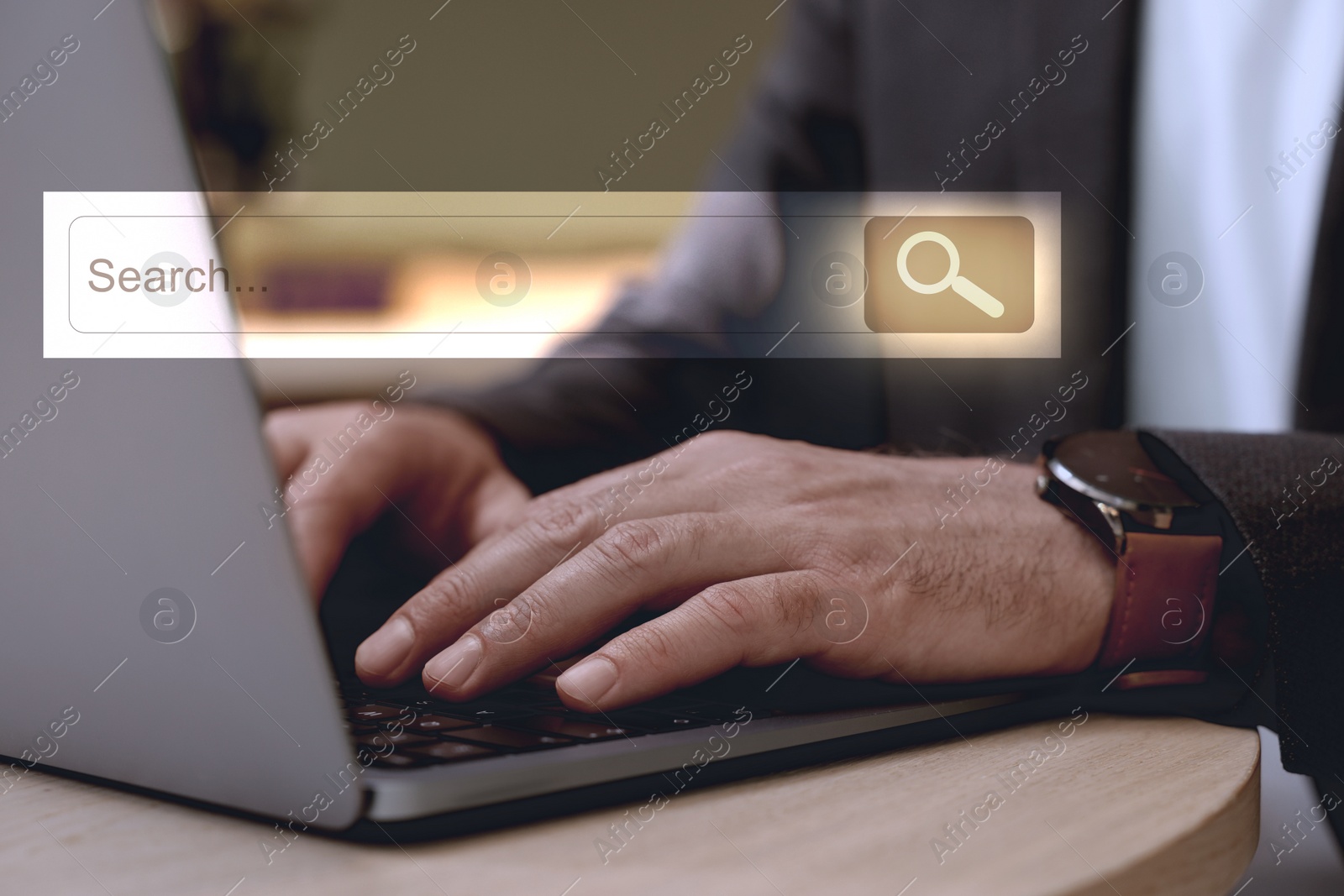 Image of Search bar of website over laptop. Man using computer at wooden table, closeup