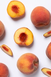 Cut and whole fresh ripe peaches on white background, flat lay