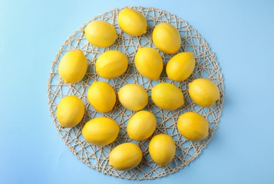 Photo of Ripe fresh lemon fruits on light blue background, top view