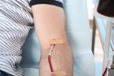 Photo of Man making blood donation at hospital, closeup