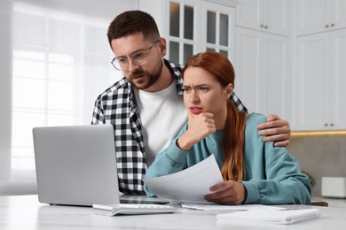 Couple using laptop for paying taxes at home