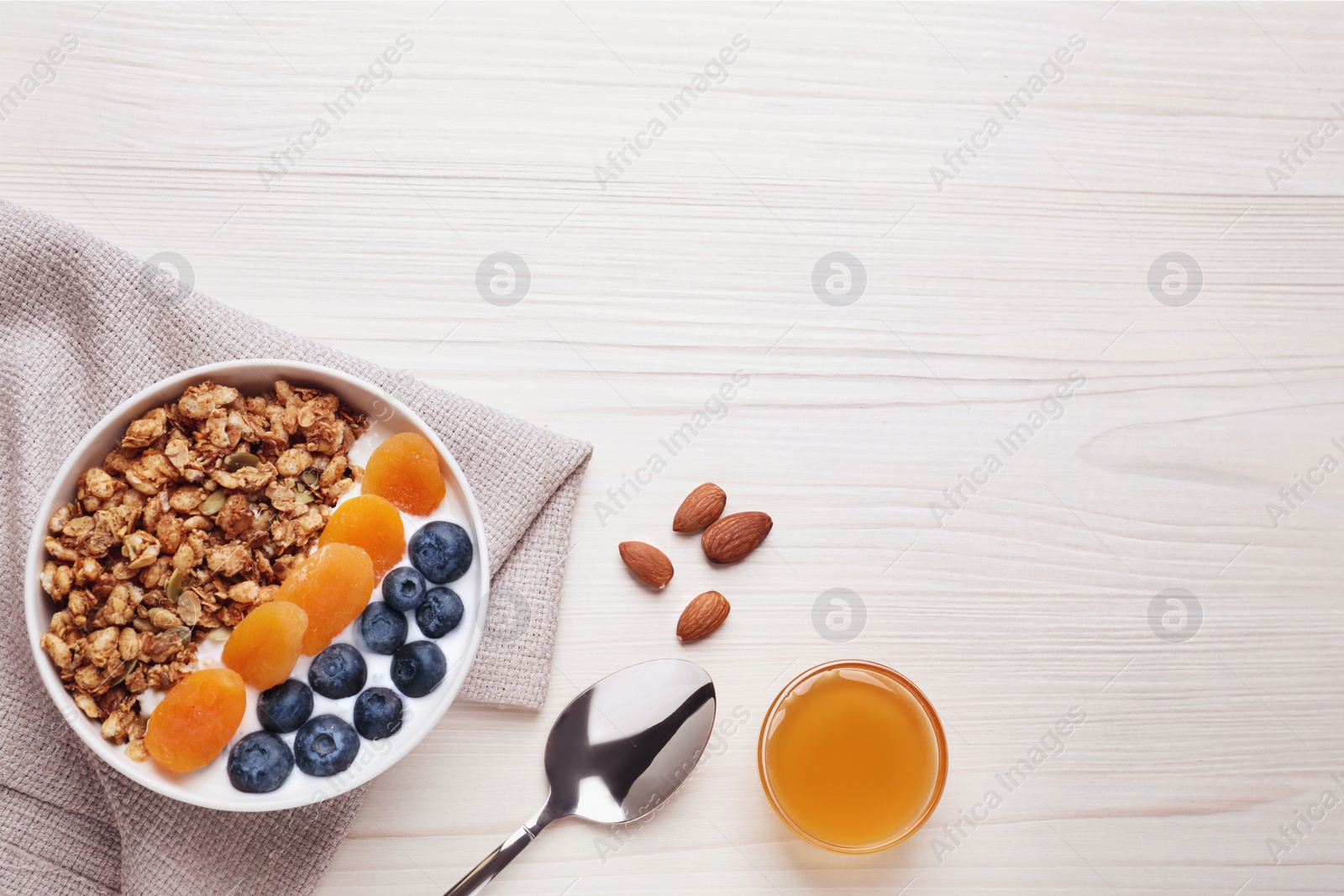 Photo of Delicious granola with fruits on white wooden table, flat lay. Space for text