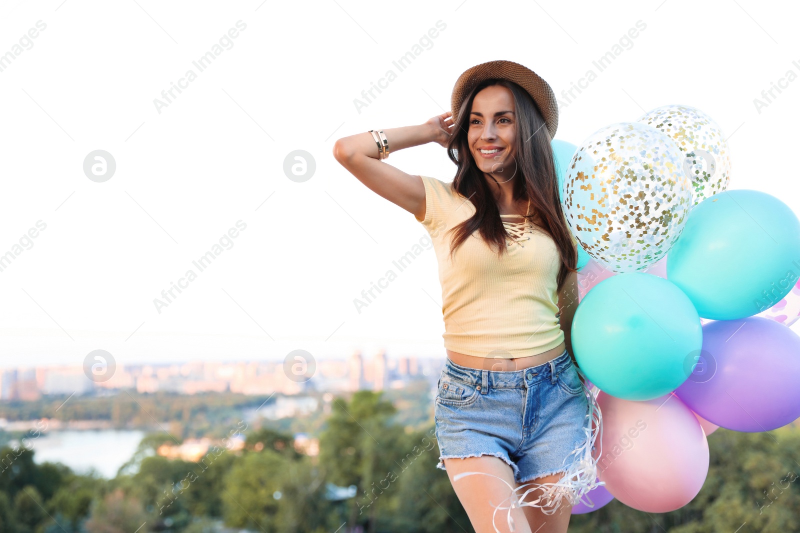 Photo of Beautiful young woman with color balloons outdoors