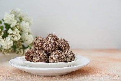 Delicious sweet chocolate candies on beige table, space for text