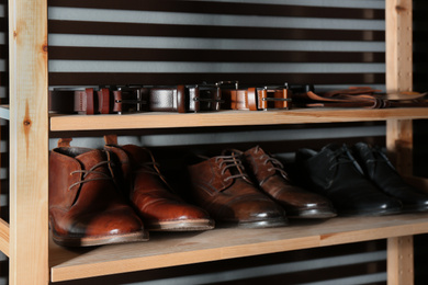 Wooden shelving unit with different leather shoes and belts