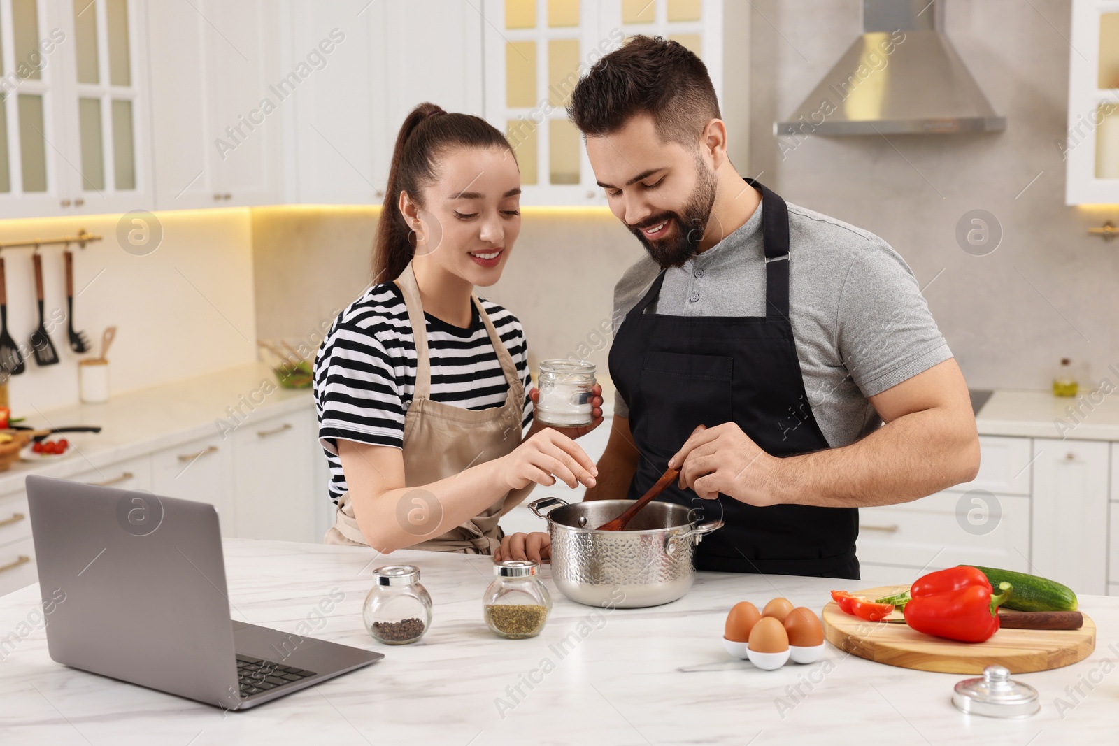 Photo of Lovely young couple cooking together in kitchen