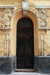 Photo of Entrance of house with arched wooden door and beautiful moldings