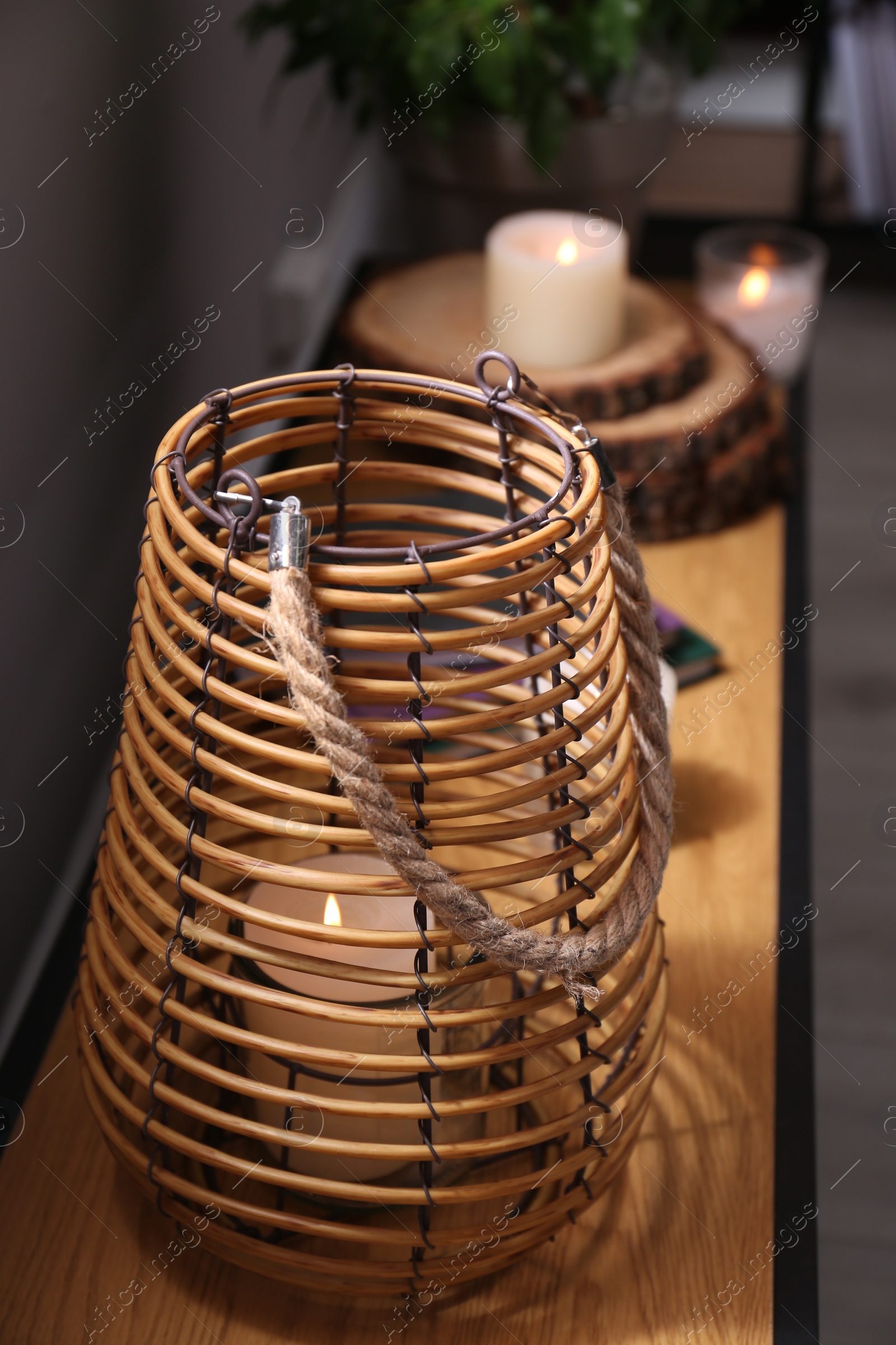 Photo of Burning scented candles on wooden console table in room