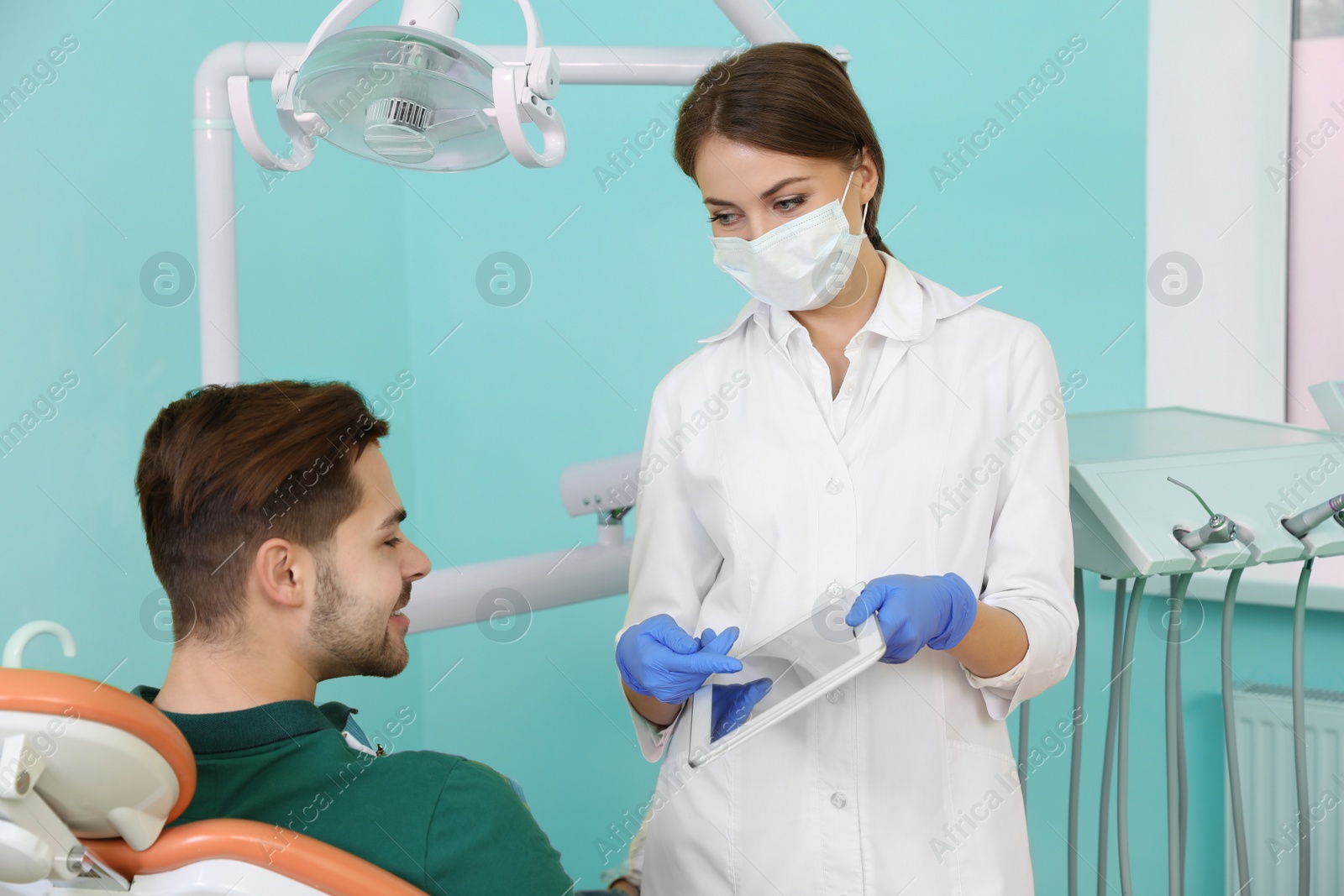 Photo of Professional dentist and patient in modern clinic