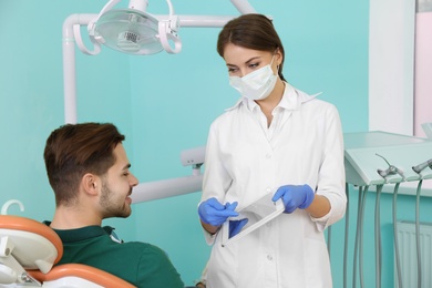 Photo of Professional dentist and patient in modern clinic