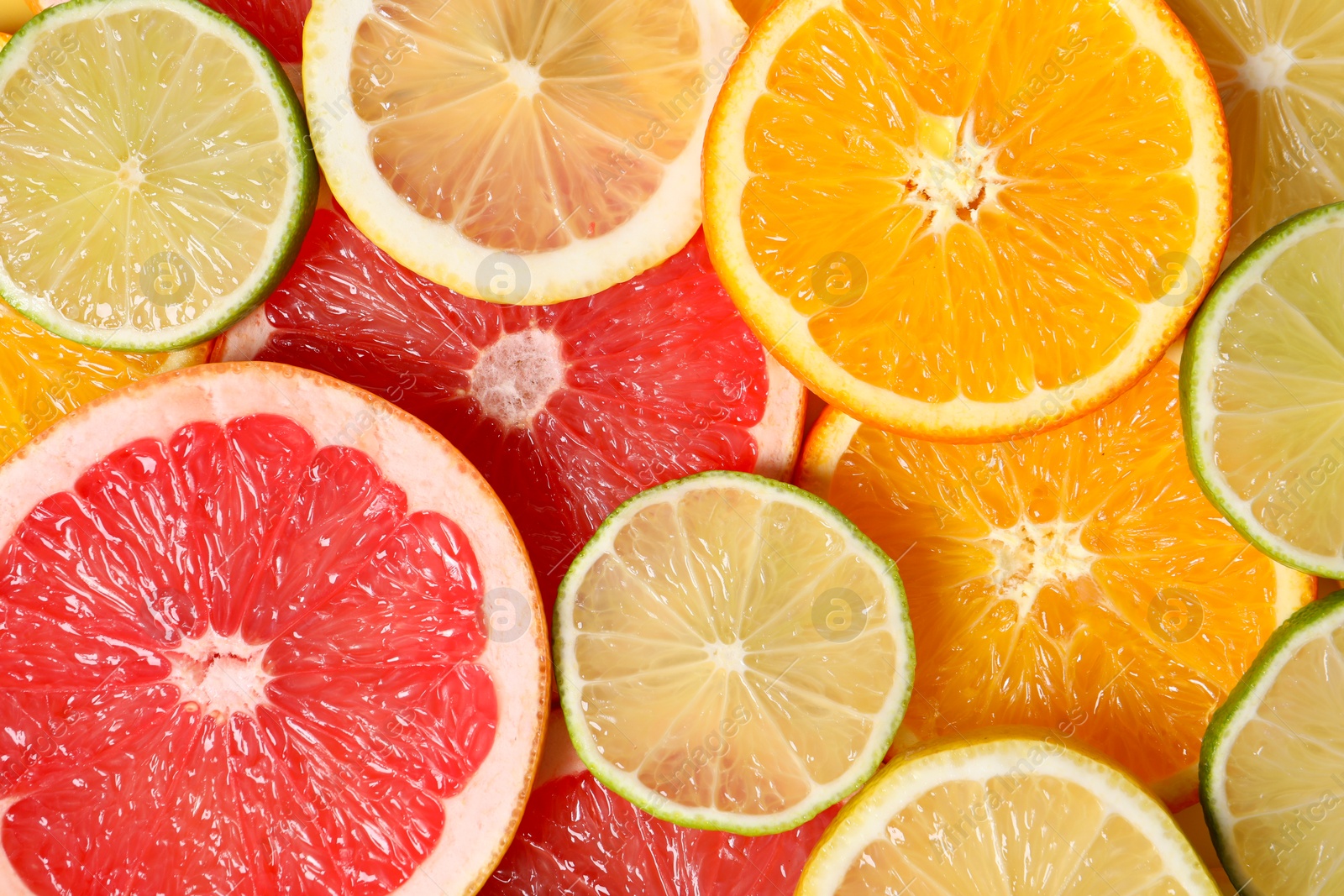 Photo of Different sliced citrus fruits as background, top view