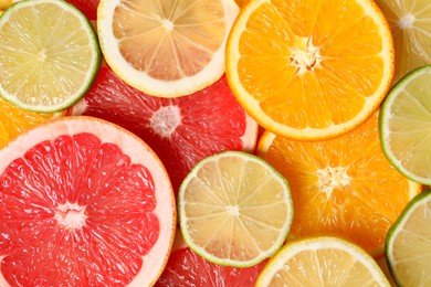 Different sliced citrus fruits as background, top view