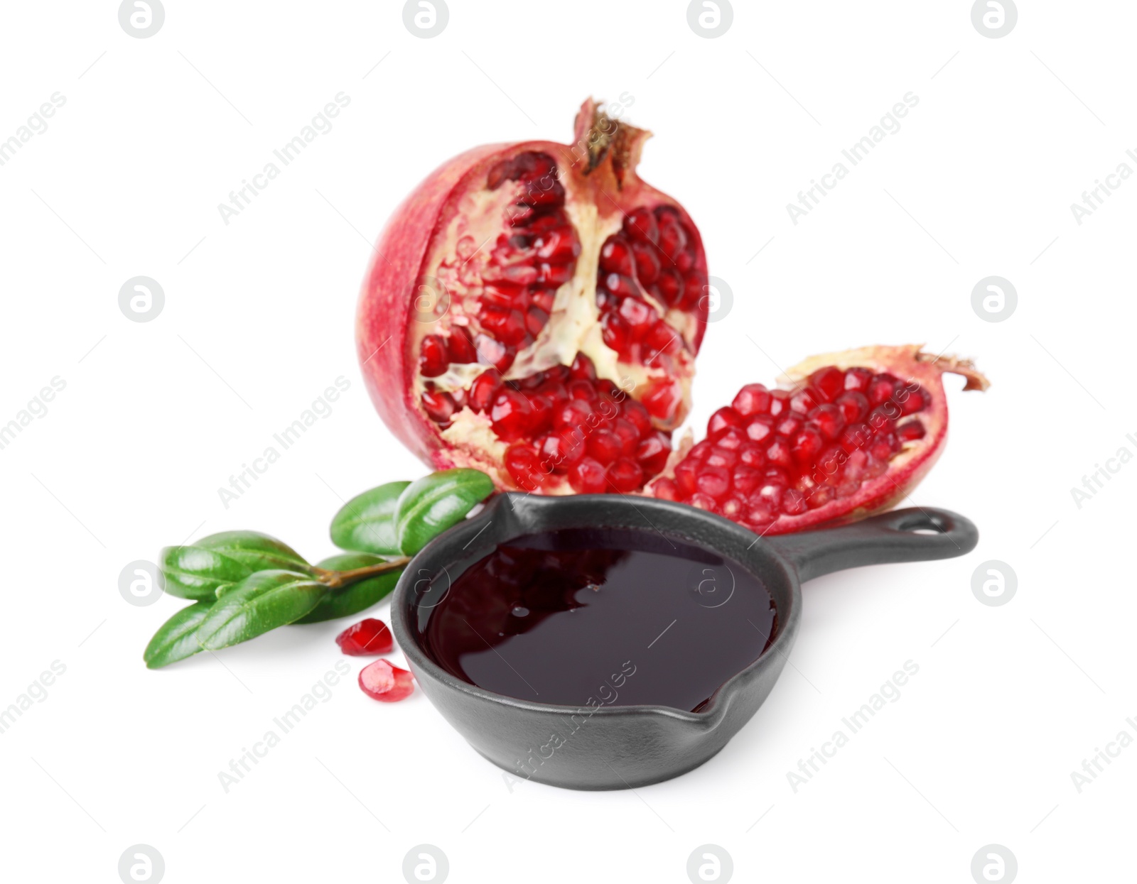 Photo of Tasty pomegranate sauce in bowl, branch and cut fruit isolated on white