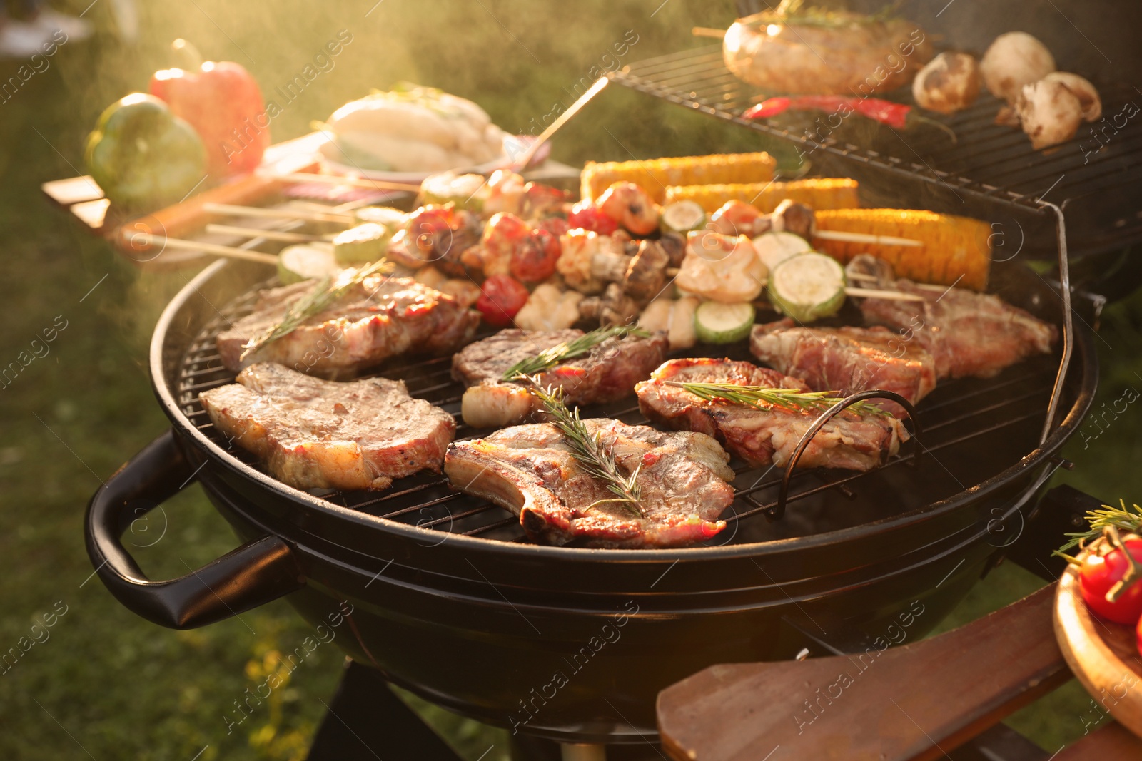 Photo of Cooking meat and vegetables on barbecue grill outdoors