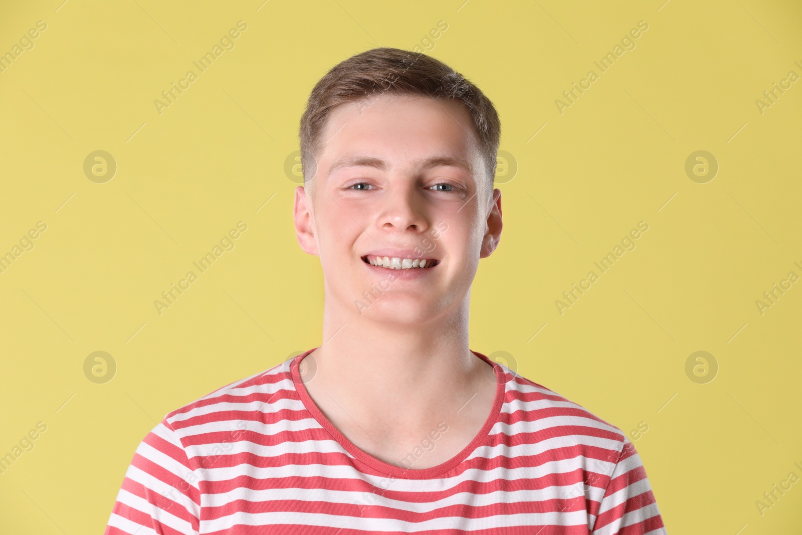 Photo of Portrait of teenage boy on yellow background