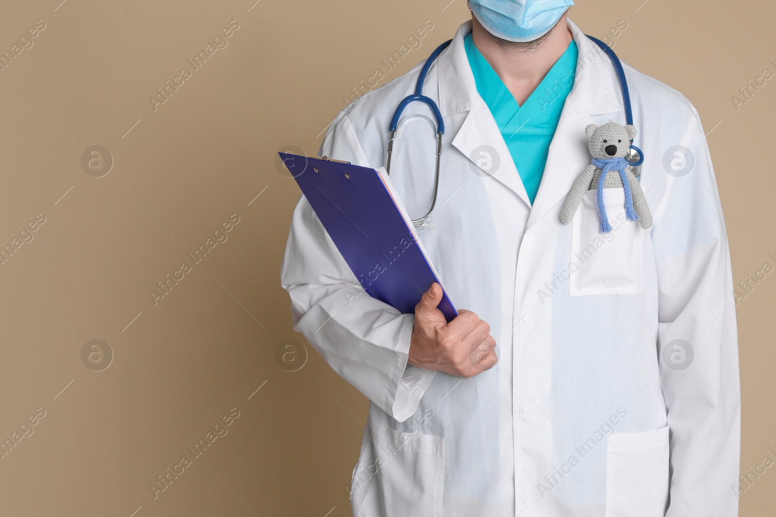 Photo of Pediatrician with toy bear and stethoscope on beige background, closeup. Space for text