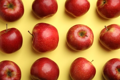 Flat lay composition with ripe juicy red apples on yellow background