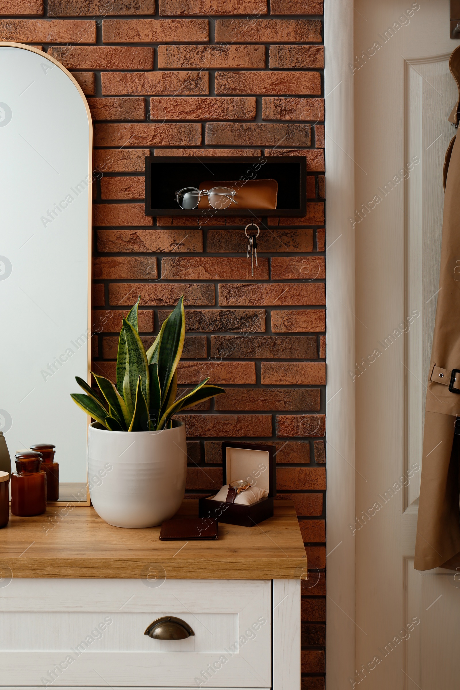 Photo of Stylish hanger for keys on brick wall in hallway