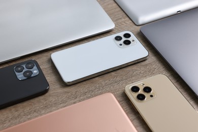 Photo of Many different modern gadgets on wooden table