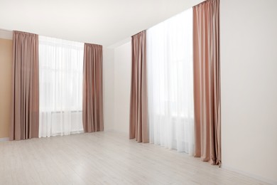 Photo of Elegant window curtains and white tulle indoors. Interior design