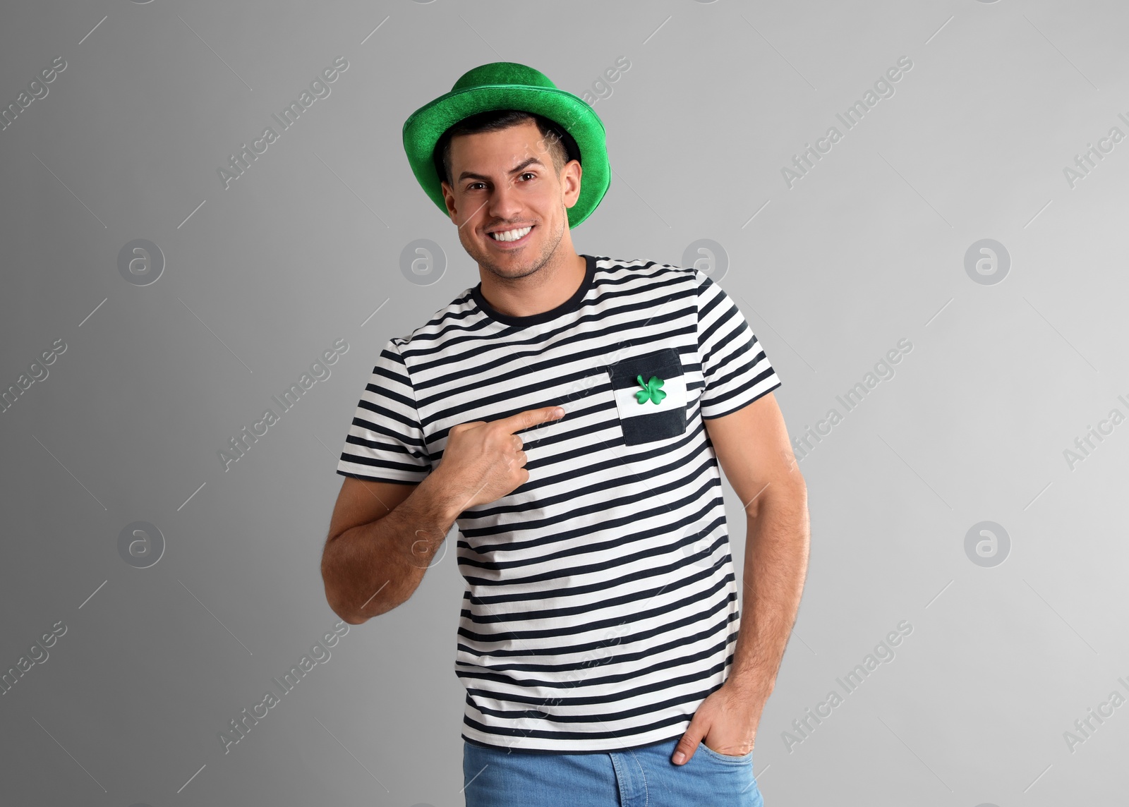 Photo of Happy man in St Patrick's Day outfit on light grey background