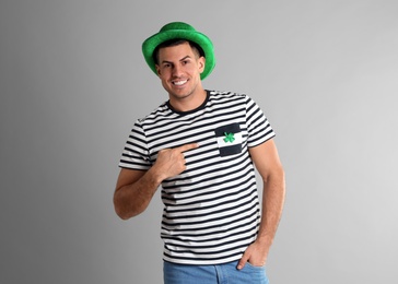Happy man in St Patrick's Day outfit on light grey background