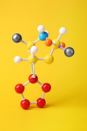 Photo of Structure of molecule on yellow background. Chemical model