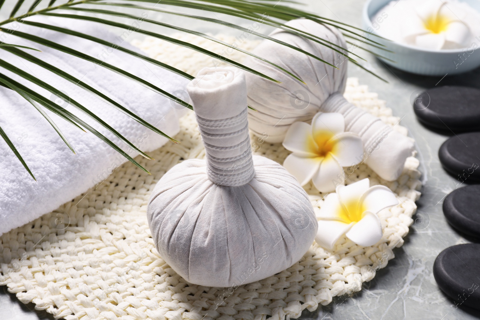 Photo of Spa bags, stones and orchid flowers on light gray marble table