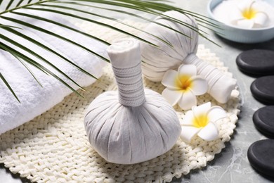 Spa bags, stones and orchid flowers on light gray marble table