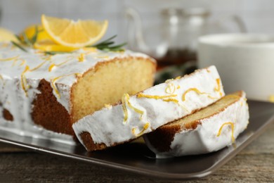 Photo of Tasty lemon cake with glaze on wooden table, closeup