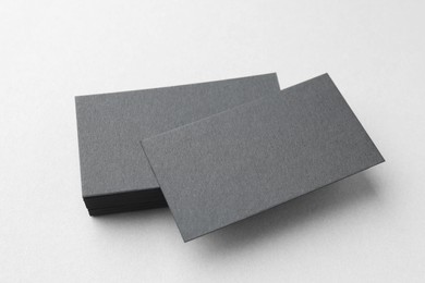 Blank black business cards on white table, above view. Mockup for design