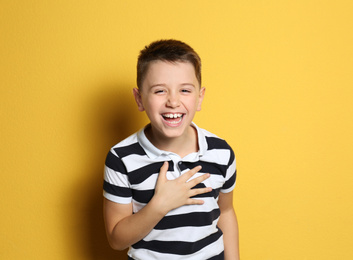 Photo of Portrait of emotional preteen boy on yellow background