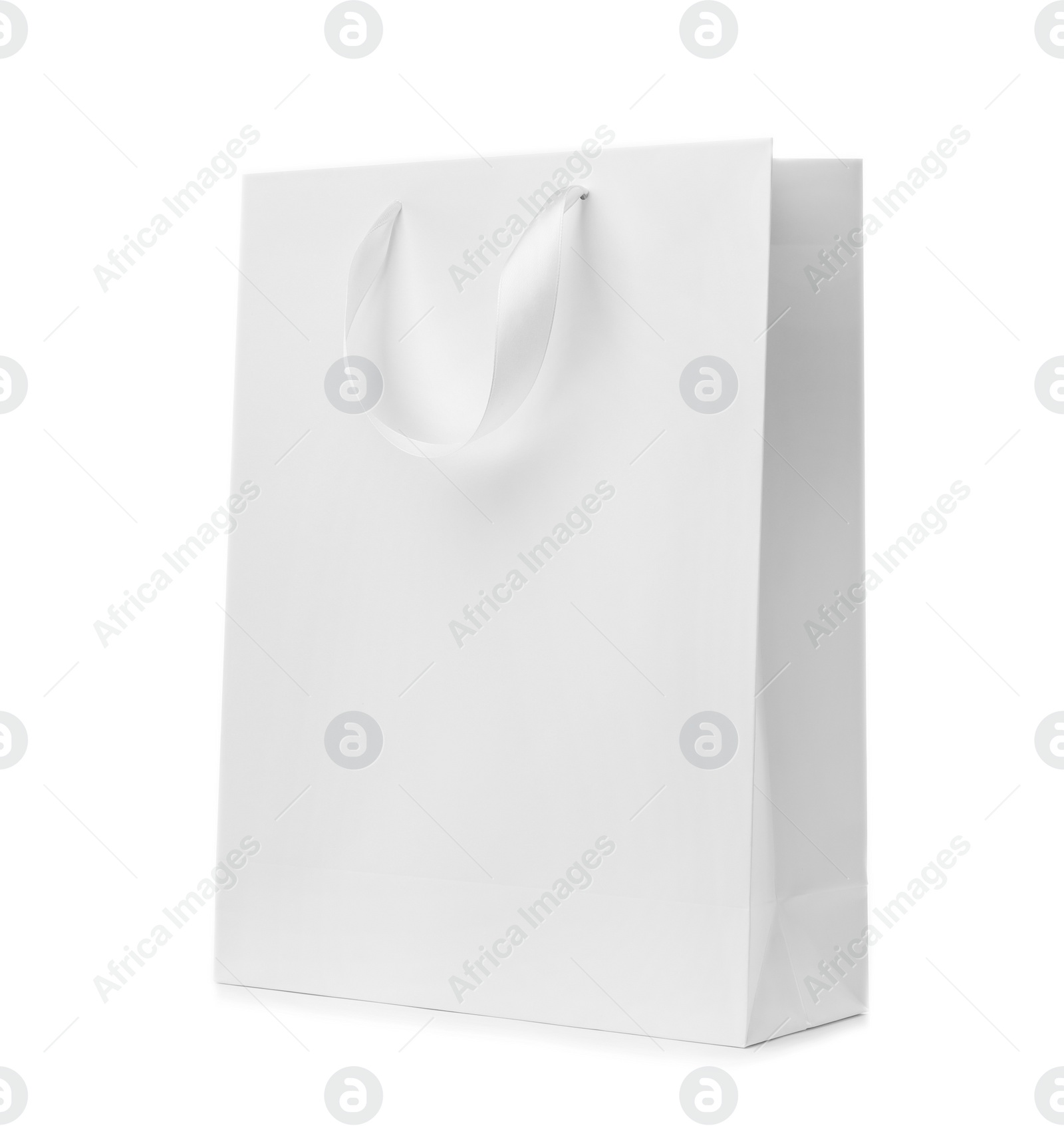 Photo of Paper shopping bag with ribbon handles on white background. Mockup for design