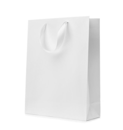 Paper shopping bag with ribbon handles on white background. Mockup for design