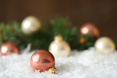 Photo of Beautiful Christmas ball on snow against blurred background. Space for text