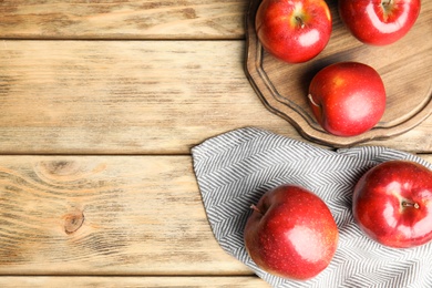 Photo of Flat lay composition with ripe juicy red apples on wooden table. Space for text