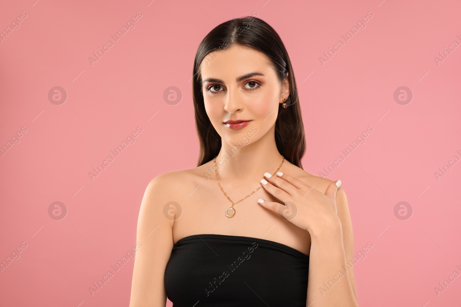 Photo of Beautiful woman with elegant jewelry on pink background