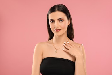 Beautiful woman with elegant jewelry on pink background