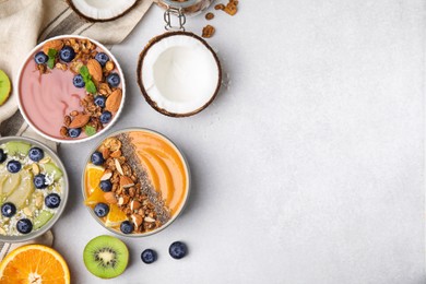 Photo of Bowls with different delicious smoothies and fresh ingredients on white table, flat lay. Space for text