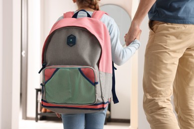 Photo of Little girl with father at home. Ready to go to school