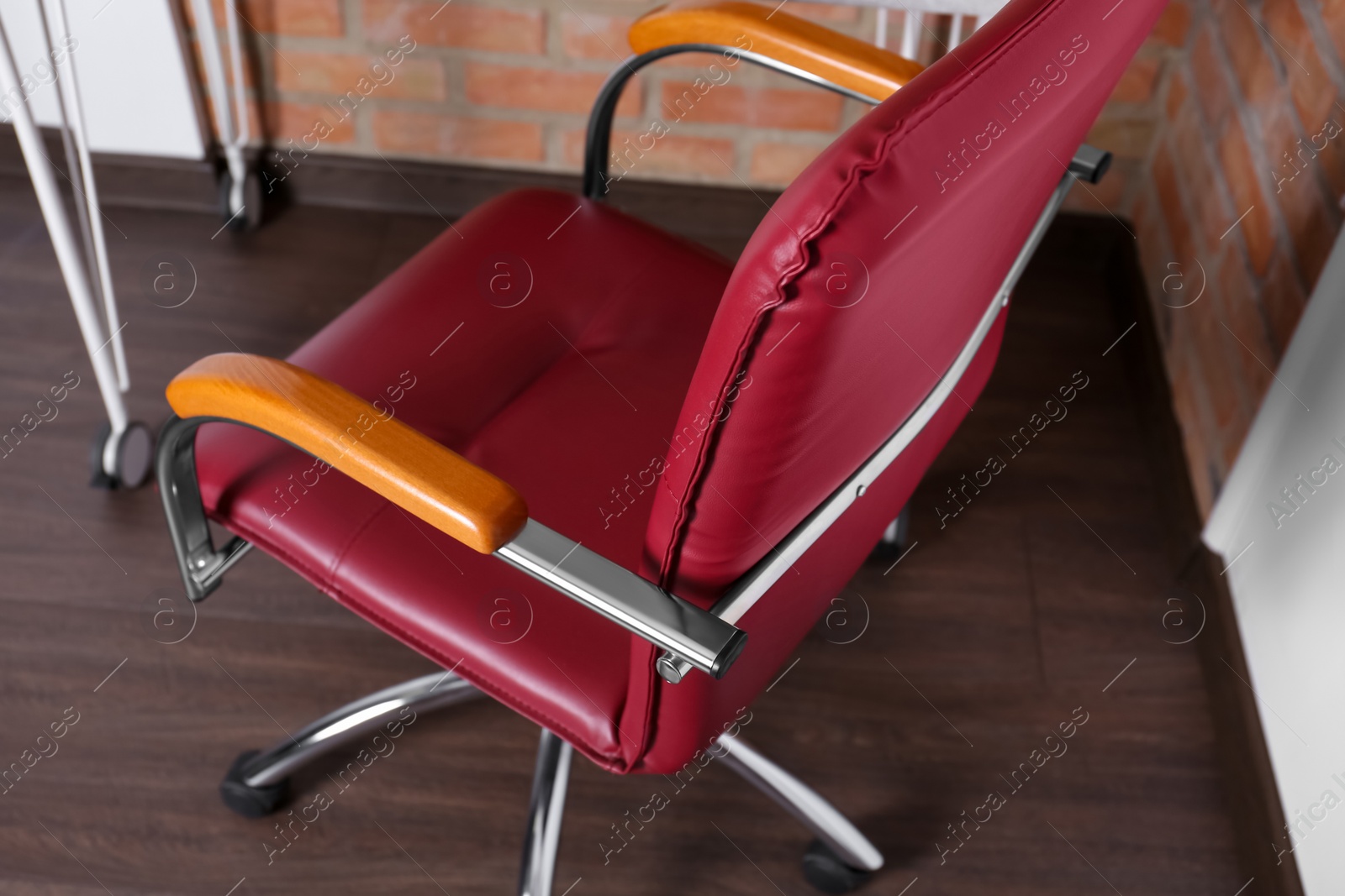 Photo of Comfortable red desk chair in modern office, closeup