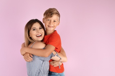 Photo of Portrait of mother and son on color background