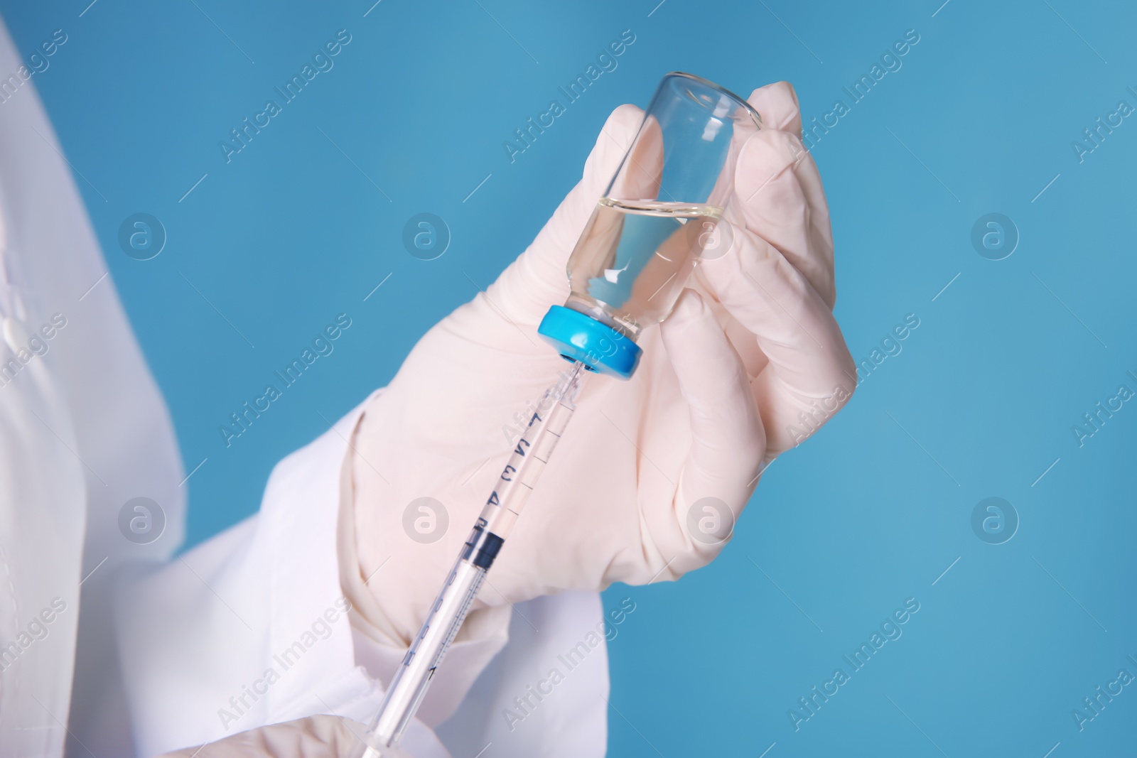 Photo of Doctor with syringe and medicine for vaccination on color background