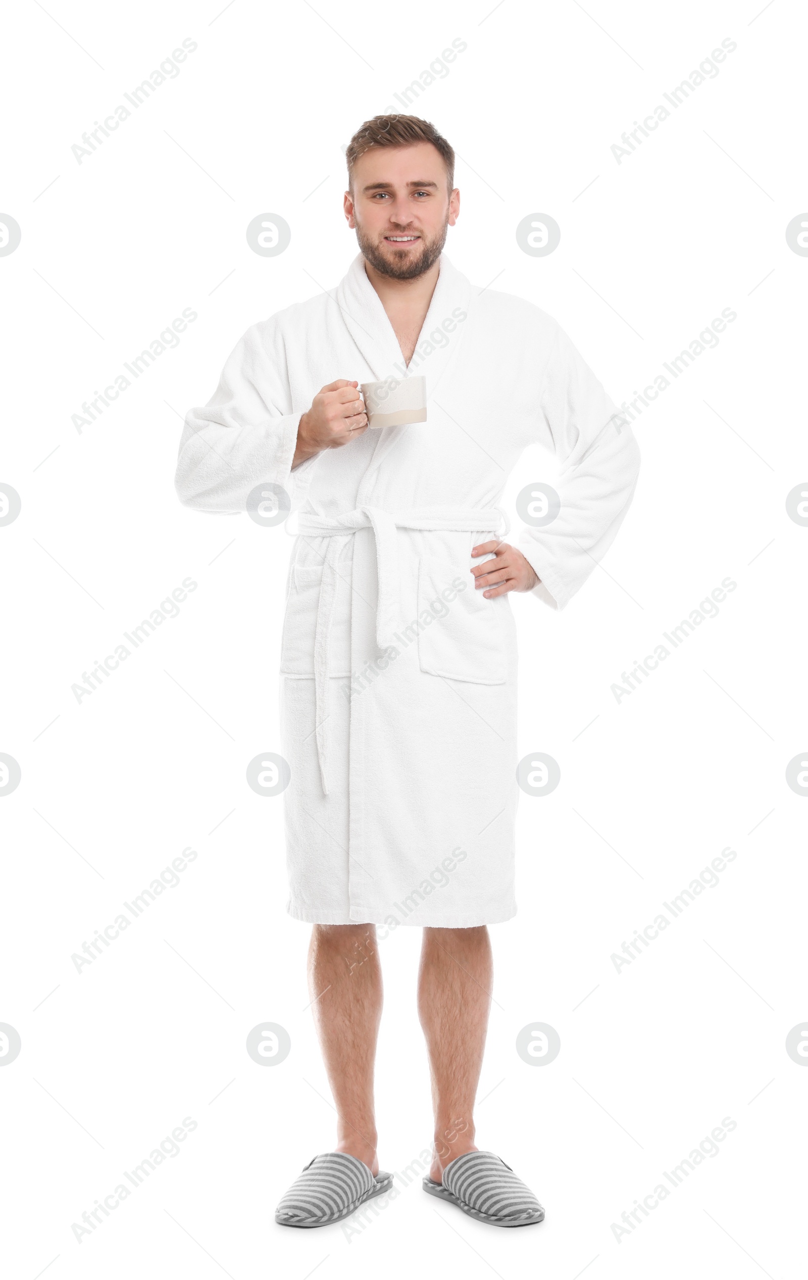 Photo of Handsome man in bathrobe with cup of coffee on white background