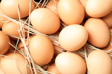 Photo of Pile of raw brown chicken eggs, top view