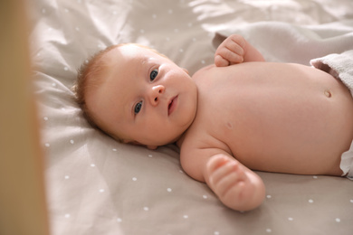 Photo of Cute little child lying in cot. Healthy baby