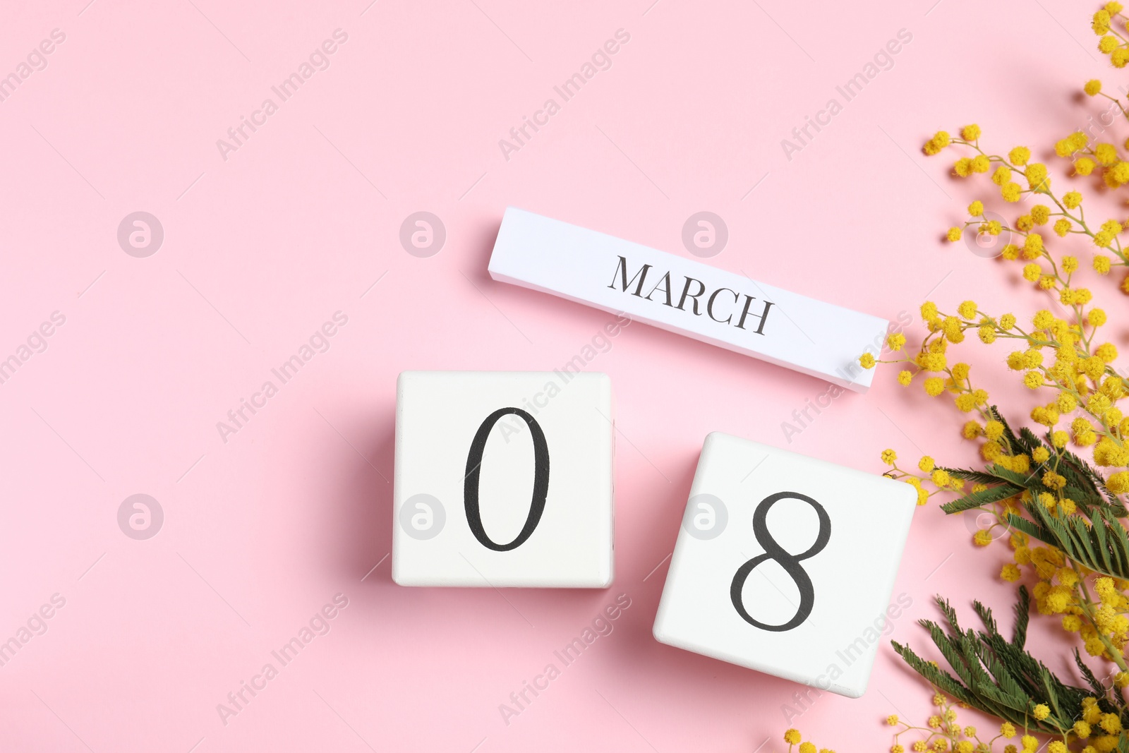 Photo of International Women's day - 8th of March. Wooden block calendar and beautiful flowers on pink background, flat lay