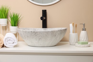 Photo of Different bath accessories and personal care products near sink on bathroom vanity