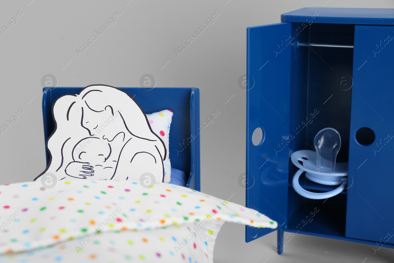 Photo of Maternity leave concept. Baby pacifier, paper cutout of mother and child in toy room