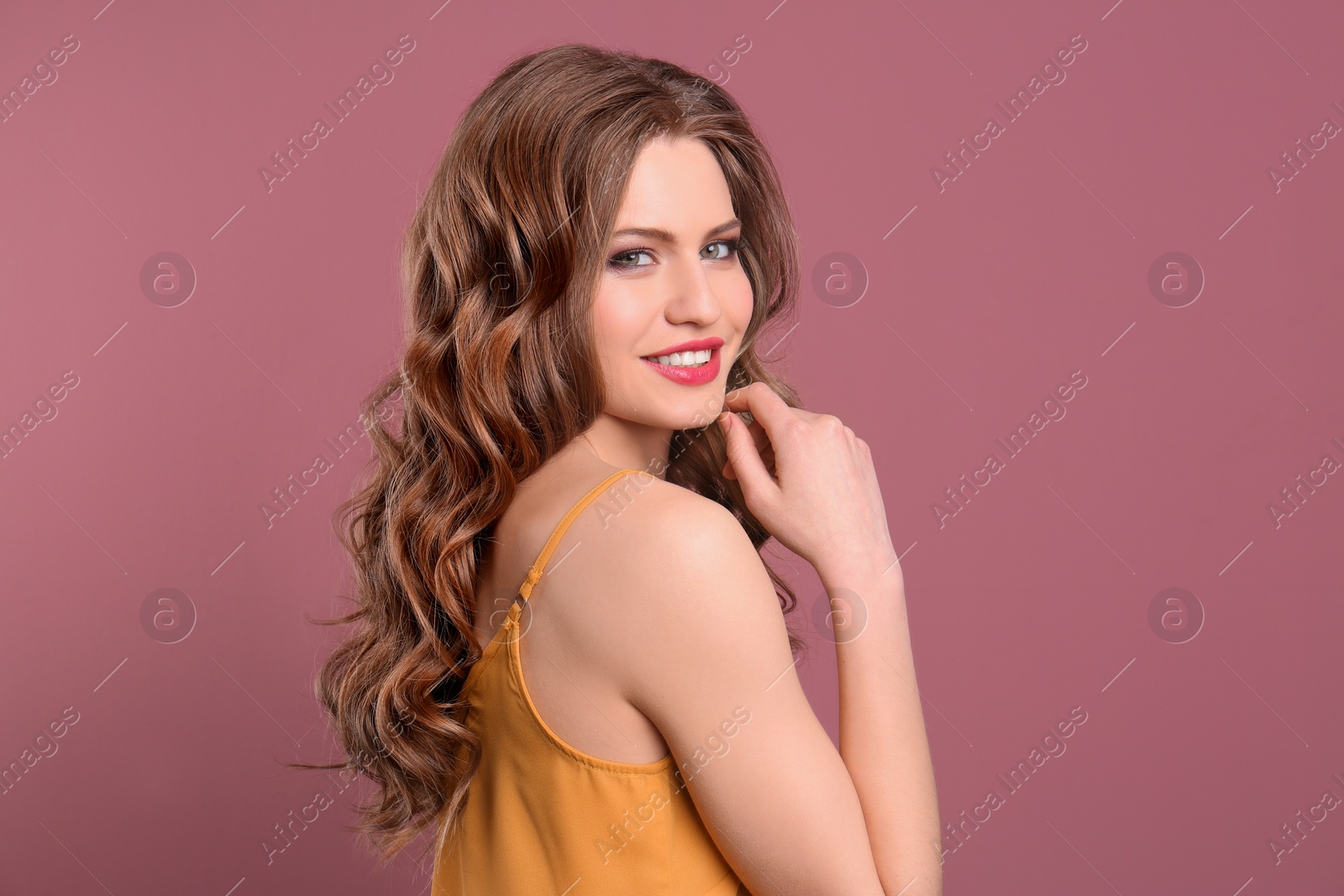 Photo of Portrait of young woman with long beautiful hair on color background